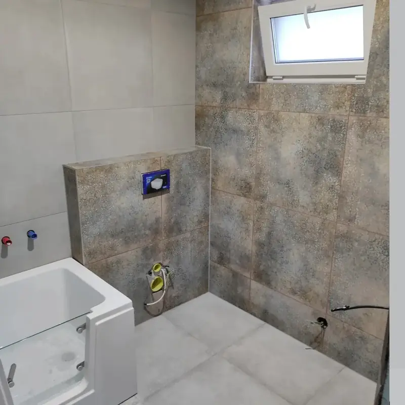 Kúpeľňa s dekoratívnym obkladom a vaňou s dvierkami