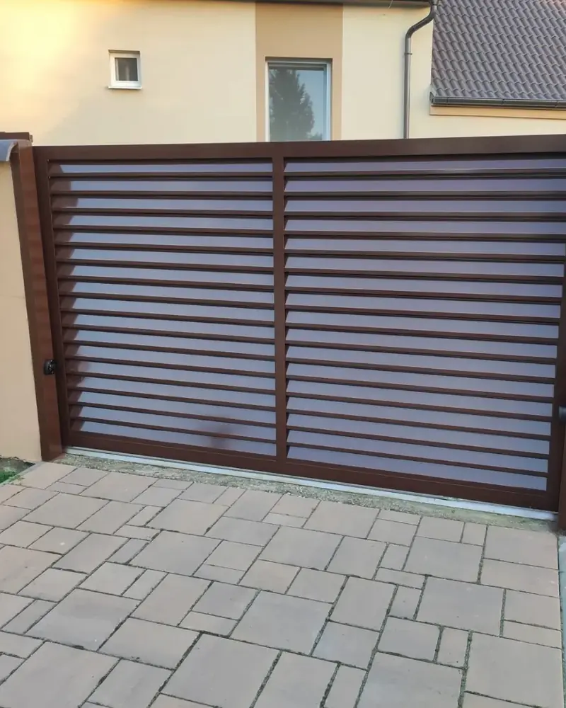 Hnedá posuvná brána a dlažba pred domom